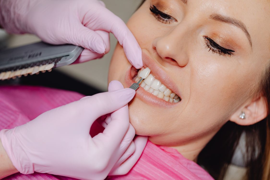 Dental lab technician fabricating porcelain feldspathic veneers — hand-stacking ceramic on refractory die
