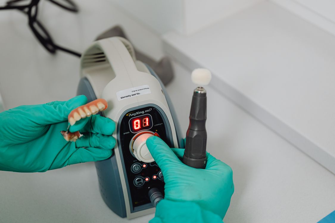 Dental lab technician performing documented final quality inspection — ISO 13485 requires recorded quality checks for every restoration